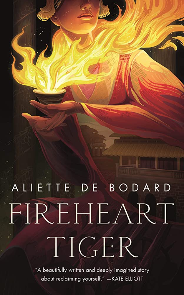 The cover for Fireheart Tiger. It features a woman dressed in fine Viet-inspired clothing holding a tea cup from which a great deal of fire is rising, wrapping around her neck and chest.